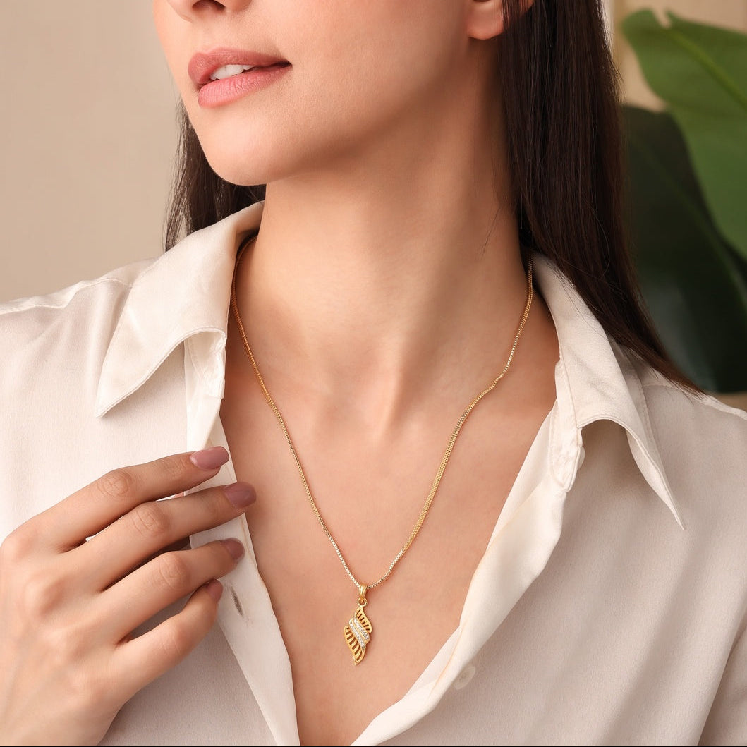 Woman wearing a gold necklace against a neutral background