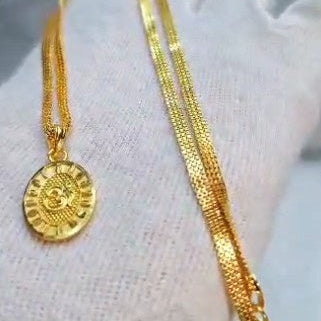 Gold necklace with a pendant on a white surface