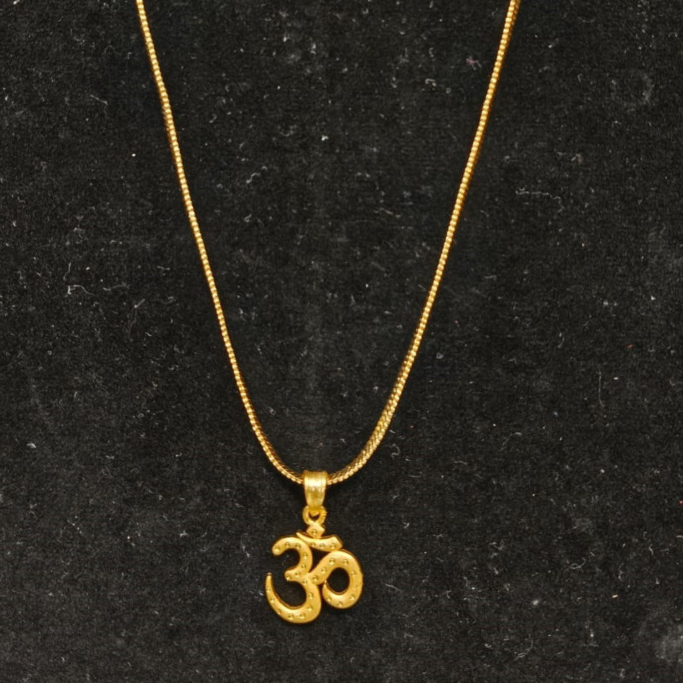 Gold necklace with Om pendant on a black background